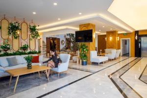 a woman sitting on a chair in a lobby at Güllük Elegance Otel in Gulluk