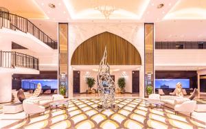 a lobby with chairs and a statue in the middle at Hilton Samarkand Regency in Samarkand