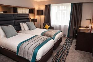 a hotel room with two beds and a television at Crowne Plaza Felbridge - Gatwick, an IHG Hotel in East Grinstead