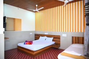 a bedroom with two beds and a mirror at P P Lodging in Pune