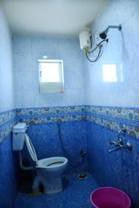 een blauwe badkamer met een toilet en een raam bij P P Lodging in Pune