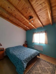 a bedroom with a blue bed and a window at La Malargüina in Malargüe
