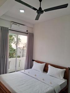 um quarto com uma cama grande e uma janela em RKO Villa27 em Habaraduwa Central