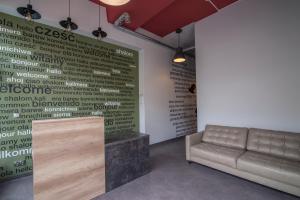 a waiting room with a couch and a wall withcriptions at 110 Hostel in Gdynia