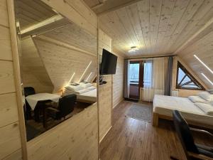 a room with two beds and a table and chairs at Pienińska Willa Aleksandrówka in Szczawnica