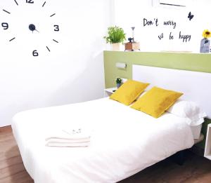 een slaapkamer met een wit bed met gele kussens bij Apartamento Loft La Magdalena in Córdoba