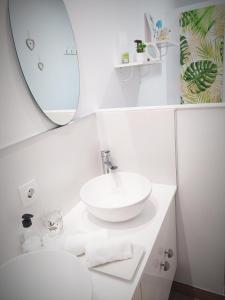 een witte badkamer met een wastafel en een spiegel bij Apartamento Loft La Magdalena in Córdoba