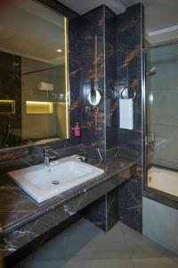 a bathroom with a sink and a glass shower at Concorde Creek View Hotel Bur Dubai in Dubai
