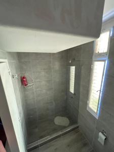 a bathroom with a shower with a toilet and a window at Casa Barrio Bombal in Mendoza