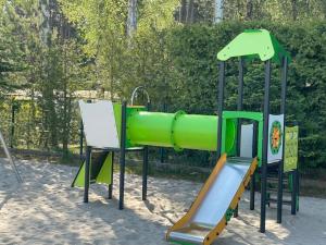 einen Spielplatz mit Rutsche im Sand in der Unterkunft Apartament Silence Baltic Royal Gold in Pobierowo