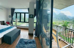 a bedroom with a bed and a balcony with a view at Trang An Legend in Ninh Binh