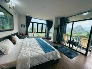 a bedroom with a large bed and large windows at Trang An Legend in Ninh Binh