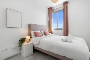 Un dormitorio con una cama grande y una ventana en Stunning townhouse with pool, gym and seaviews Ref 162, en Fuengirola
