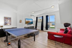 sala de estar con mesa de ping pong y sofá rojo en Stunning townhouse with pool, gym and seaviews Ref 162, en Fuengirola