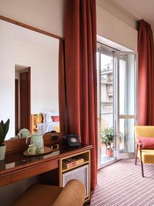 a hotel room with a desk and a bed and a window at Max Brown Hotel Missori, part of Sircle Collection in Milan