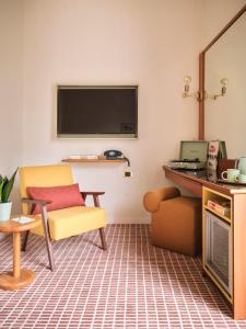 a living room with a tv and a chair at Max Brown Hotel Missori, part of Sircle Collection in Milan