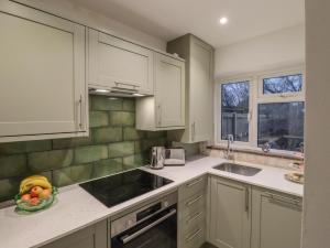 a kitchen with white cabinets and a bowl of fruit on the counter at Mabel in Whitstable