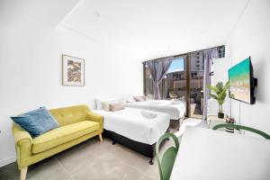 a living room with two beds and a couch at Arthur's Hotel Bondi Junction in Sydney