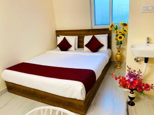 a bedroom with a bed and a sink and flowers at Hotel KP Suites Airport in Shamshabad