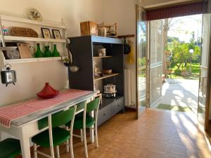 a kitchen with a table and green chairs at Villa Margherita in Lecce