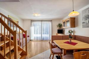 a living room with a table and a dining room at Apartments Perfila Ferienchalet in Valdaora