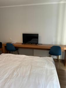 a bedroom with a desk with a computer and two chairs at Orbi Palace Studio Apartment in Bakuriani