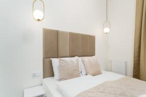 a bedroom with a bed with white sheets and pillows at Apartament Marmurowy Ku Morzu by Holidaysun in Sianozety