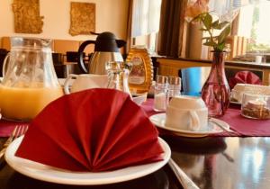una mesa con un plato con una servilleta roja. en Landgasthof Meja, en Radibor