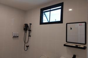 a bathroom with a shower and a television on the wall at It my life cafe x camp in Ban Tha Sai