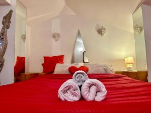 a bedroom with a red bed with two towels on it at L'Attichetto con aria condizionata-Centro Velletri in Velletri