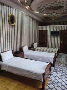 a room with three beds in a room at SHAHNOZA GRAND in Samarkand