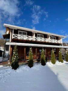 ein Haus mit Schnee davor in der Unterkunft Zarichna Lyks in Slawske