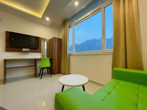 a living room with a green couch and a table at Wanna Stay Rishikesh in Rishīkesh
