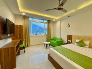 a bedroom with a bed and a television and a chair at Wanna Stay Rishikesh in Rishīkesh