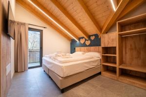 a bedroom with a bed and a large window at Residence Piz Aot in Mezzana