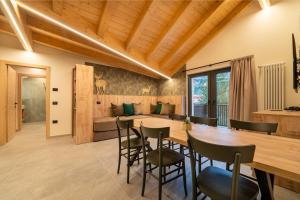 a dining room and living room with a wooden table and chairs at Residence Piz Aot in Mezzana