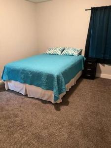 Serene 4 BR Home Near Weatherford-19 Minute Drive في Mineral Wells: غرفة نوم مع سرير مع لحاف أزرق