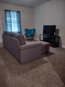 Serene 4 BR Home Near Weatherford-19 Minute Drive في Mineral Wells: غرفة معيشة بها أريكة وتلفزيون