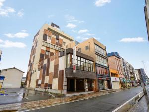 un edificio alto en una calle de la ciudad con en Hotel New Gaea Iizuka, en Iizuka