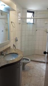 uma casa de banho com um lavatório, um WC e um chuveiro em ferratti em Guarapari
