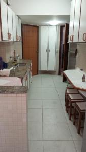 a large kitchen with white tile floors and counters at ferratti in Guarapari