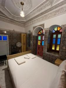 非斯的住宿－Riad Fes Unique，配有床和彩色玻璃窗的房间