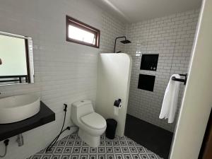 ein weißes Badezimmer mit Toilette und Waschbecken in der Unterkunft Chansi Beachresort in Tha Sala