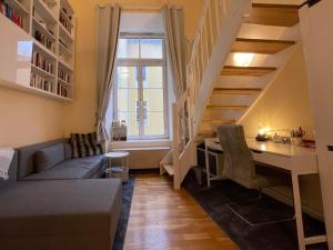 a living room with a desk and a staircase at Cute, Quiet and Central - Self Check In in Bad Ischl