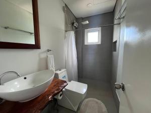 y baño con lavabo, aseo y espejo. en Blue Lagoon Inn & Suites en Puerto Princesa