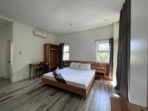 een slaapkamer met een groot bed en een bureau bij Blue Lagoon Inn & Suites in Puerto Princesa City