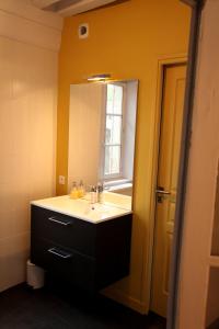 a bathroom with a sink and a mirror at La Berjotine - Maison d'hôtes in Charolles