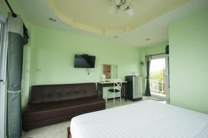 a bedroom with a bed and a couch and a television at Hotel Viewpoint Khao Koh in Khao Kho