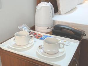 大諾伊達的住宿－Angel NRI House，桌子上两杯,配有咖啡壶
