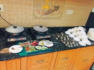 グレーター・ノイダにあるAngel NRI Houseの食器と食べ物を揃えたキッチンカウンター